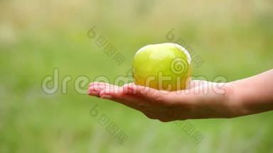 男人拿苹果躺在女人`手上。 交流，善良，关爱.. 女孩拿着苹果给它